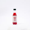 A bottle of Scarlet Rose, a cold hibiscus tea in Kenya, featuring a red liquid, with a white label displaying the brand name and product name.
