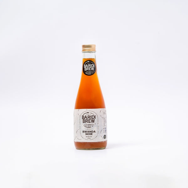 A glass bottle of Rwanda Noir, an Ice Brew Tea in Kenya, with a white label, displaying the brand name 'Baridi Brew' and the product name 'Rwanda Noir, Black Tea'.